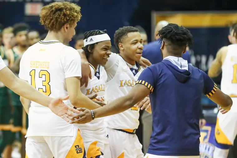 La Salle guard Khalil Brantley (second from left) and Jhamir Brickus walk off arm-in-arm after defeating George Mason at Tom Gola Arena on  Feb. 5, 2022.