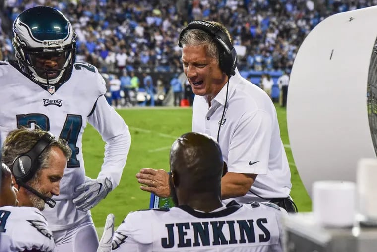 Eagles defensive coordinator Jim Schwartz talks to the defensive backs on the sideline during the 28-23 victory over the Carolina Panthers.