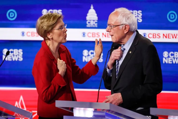 Sen. Elizabeth Warren (left, D-Mass.) talks with Sen. Bernie Sanders (I-Vt.) on stage after the Democratic presidential primary debate on Tuesday.