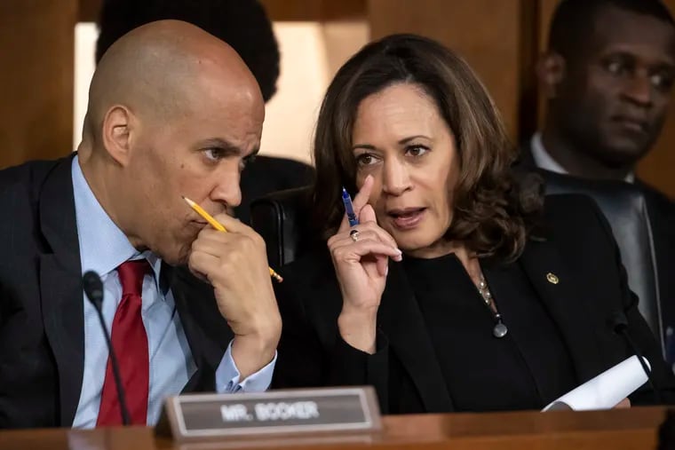 Sen. Cory Booker, D-N.J., left, and Sen. Kamala Harris, D-Calif., confer on Capitol Hill. Booker and Harris have signed on to a brief with the U.S. Supreme Court supporting an African American Hollywood mogul in his civil rights case against Comcast Corp.