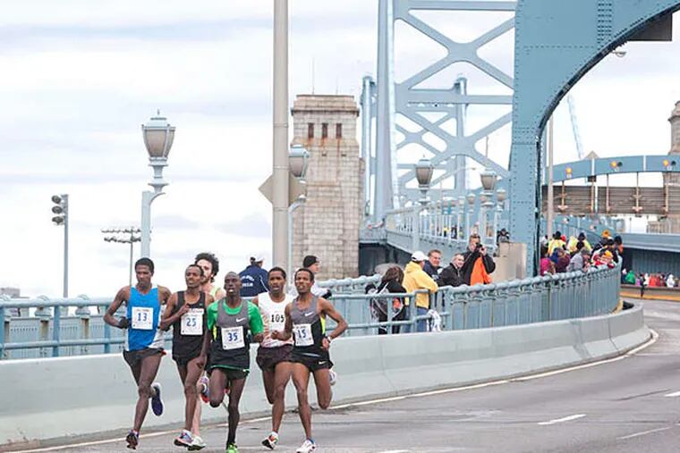 A pack of runners cross the Ben Franklin Bridge as part of Run the Bridge 10K, a fund-raiser for the Larc School, a Bellmawr nonprofit for children with moderate to severe disabilities. (Ed Hille/Staff)