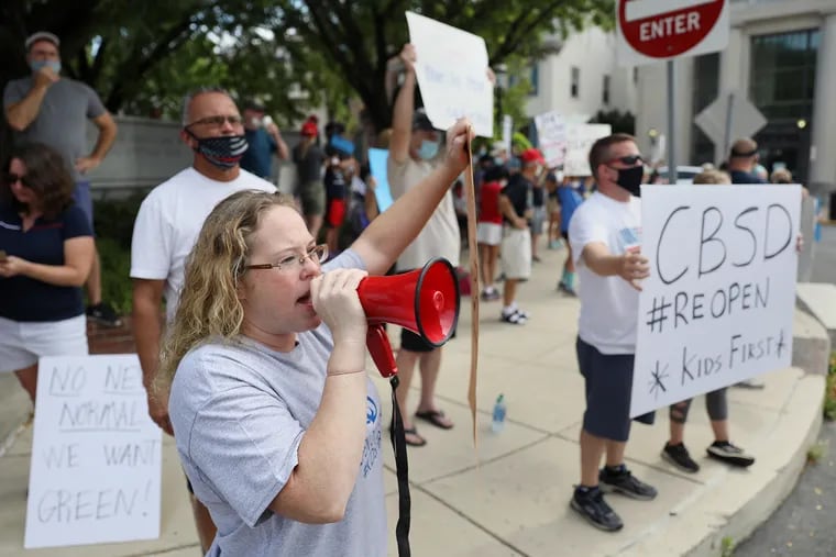 Jennifer Girard, a Central Bucks parent, speaks into a bullhorn during a protest calling for the Central Bucks School District to offer in-person classes in downtown Doylestown on Saturday.