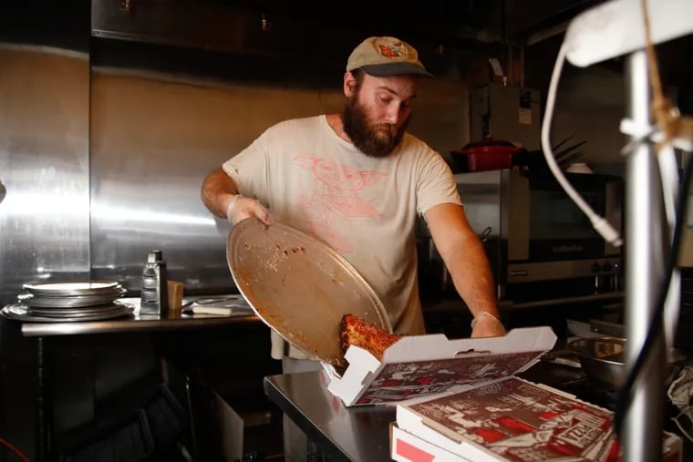 Daniel Gutter puts a fresh-made deep-dish pizza in a box at W/N W/N coffee bar on Spring Garden Street.
