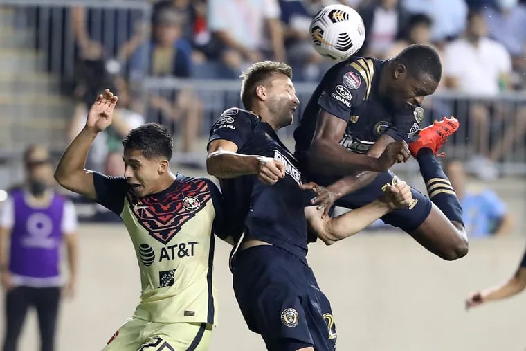 Kacper Przybylko, center and Cory Burke, right, of the Philadelphia Union collide as they try to head the ball into the goad against Salvador Reyes of Club América in the 2nd half on Sept. 15, 2021  at Subaru Stadium in Chester, PA. in a Champions League semifinals match.