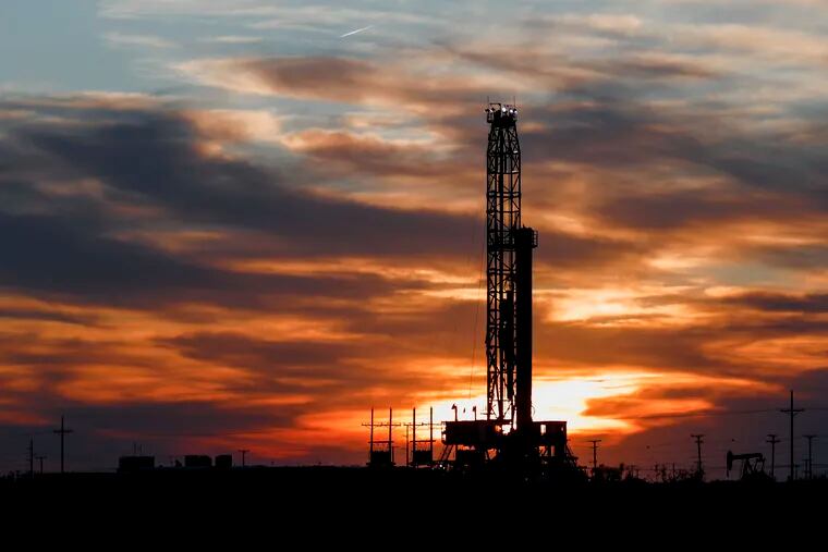 An oil rig stands against the setting sun in Midland, Texas.