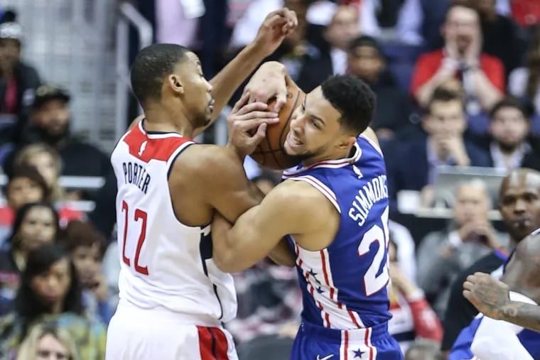 Ben Simmons, right, and the Wizards' Otto Porter Jr. wrestle for the ball during the third quarter Wednesday night.