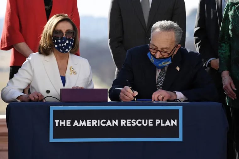 Speaker of the House Nancy Pelosi (left) and Senate Majority Leader Chuck Schumer sign the American Rescue Plan Act after the House Chamber voted on the final revised legislation of the $1.9 trillion COVID-19 relief plan, at the US Capitol on March 10, 2021 in Washington, DC.