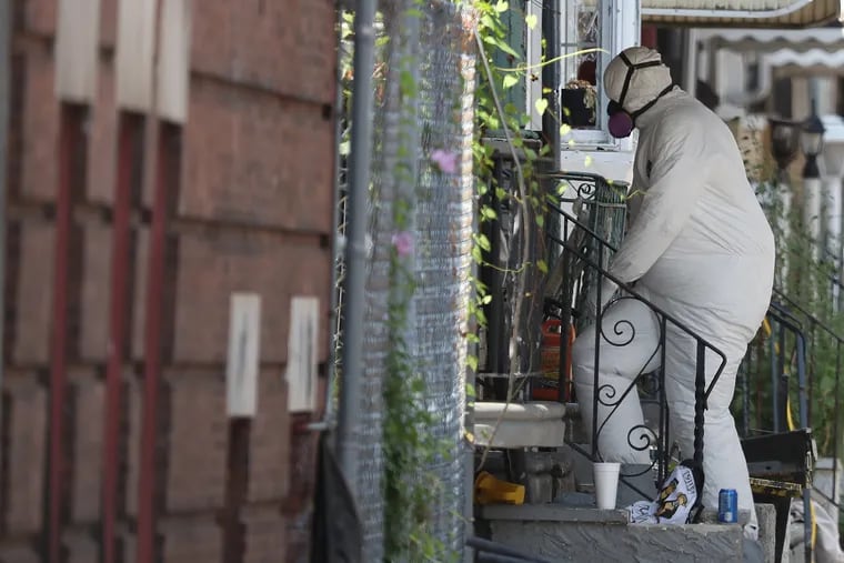 Philadelphia crime scene officer wearing a hazmat suit walks into the home of suspected gunman Maurice Hill on the 3700 block of N. 15th Street in Philadelphia, PA on August 15, 2019.