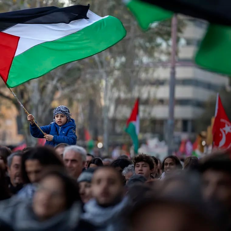 A boy waves a Palestinian flag as demonstrators march during a protest in support of Palestinians and calling for an immediate ceasefire in Gaza, in Barcelona, Spain, on Jan. 20, 2024.