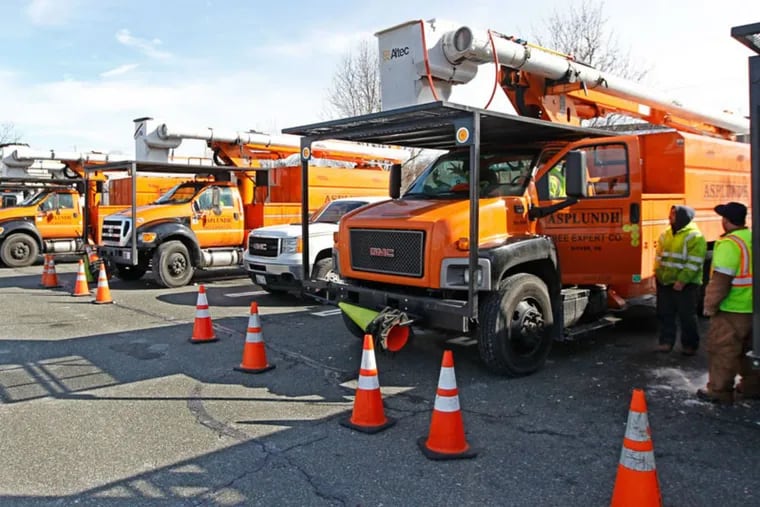 A row of Asplundh Tree Service trucks sit in the parking lot of Loews in Plymouth Meeting waiting to be dispatched by PECO to clear tree limbs off lines in Montgomery County in 2014.