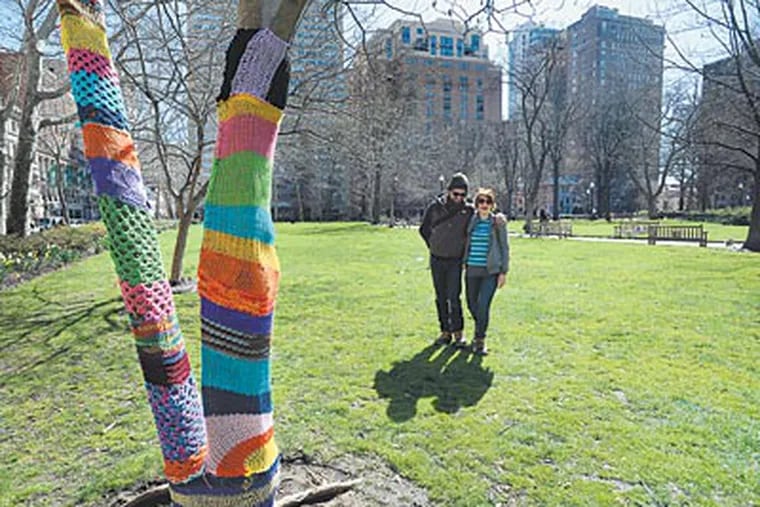 Jerry Kaba and Jessie Hemmons admire Hemmons’ handiwork in Rittenhouse Square. “Times are tough,” the graduate student says. “People want to see something bright and pretty.” (SHARON GEKOSKI-KIMMEL / Staff Photographer)
