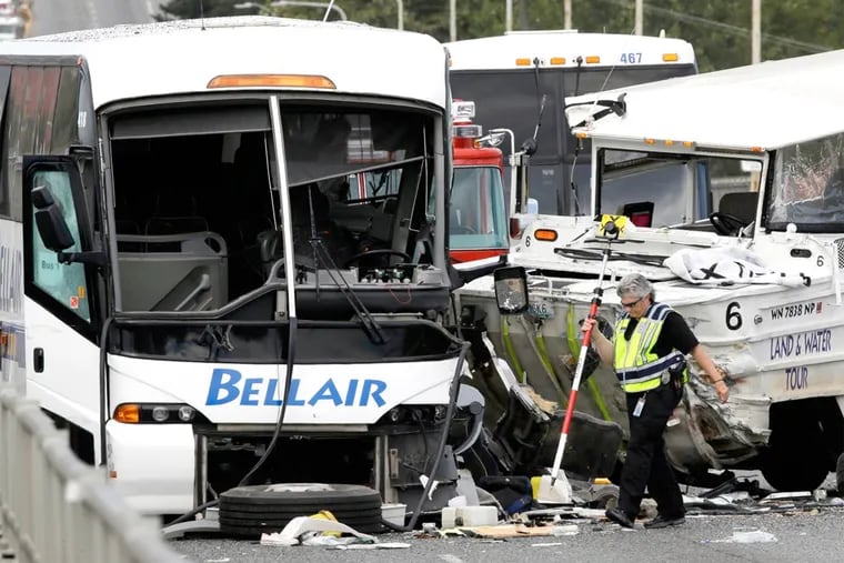 A Seattle official at the scene of a deadly crash involving a "Ride the Ducks" amphibious vehicle, right, and several other vehicles Thursday, Sept. 24, 2015, in Seattle.