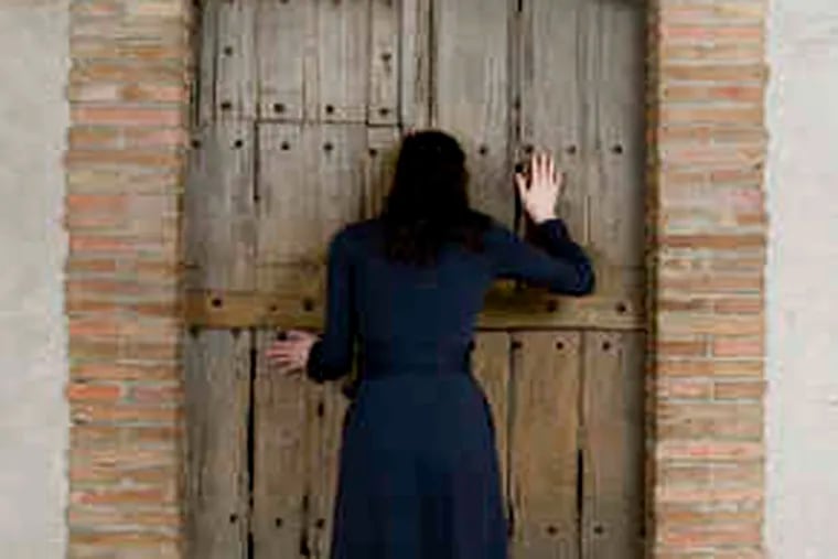 Viewing “Étant donnés,” one person at a time, peering through two peepholes in an antique wooden door.