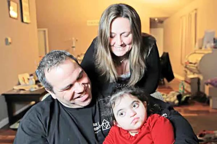 Joe Rivera and his wife Chrissy Rivera hold on tight to their daughter Amelia Rivera, 3 ( Michael Bryant / Staff photographer )