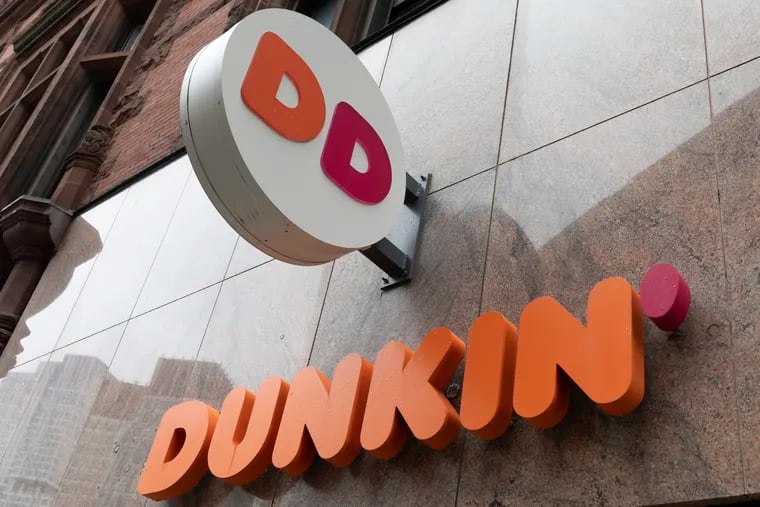 The Dunkin' logo is seen on a storefront in Boston. Workers at the manufacturing facility for a Dunkin' franchisee that owns 45 Philadelphia-area stores are trying to form a union.