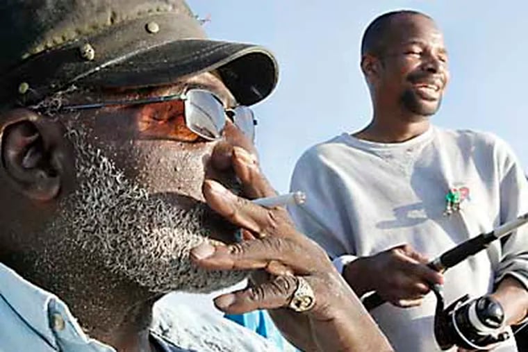 Richard "Friday" Grayson of Camden (left) was not fishing today but he was talking about fishing with Devon James of Camden who was fishing (on right) while relaxing at the Father Doyle Fishing Pier in Camden on May 18, 2012. ( ELIZABETH ROBERTSON / Staff Photographer )