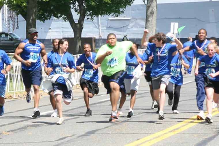 Roy Bowser (center, in green), 16, completed the Broad Street Run with the help of Run Philly Style, a nonprofit group that helps kids create and meet their goals.