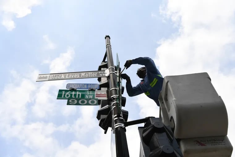 A city employee installs a sign to change the name of the street outside St. Johns Church to Black Lives Matter Plaza NW near the White House in Washington, D.C., on June 5, 2020. (Washington Post photo by Toni L. Sandys)