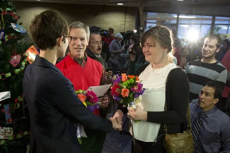 Natalie Dicou (left) and Nicole Christensen are married by Salt Lake City Ralph Becker in the Salt Lake County Clerk's Office lobby after the state's ban on same-sex marriage was overturned.