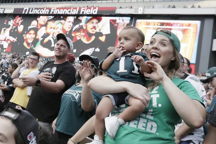 Eagles fan Kaitlyn Rivas screams as she realizes she and her 1-year-old son C.J. are being broadcast on the stadiums big screen during the open Eagles practice at Lincoln Financial Field in Phila., Pa. on Aug. 5, 2018.