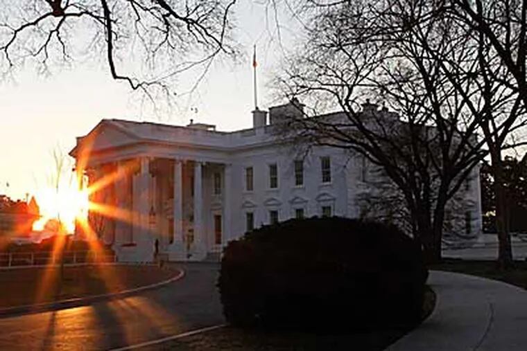 The morning sunrise beams by the White House as President Barack Obama started his first on the job. (AP Photo/Charles Dharapak)