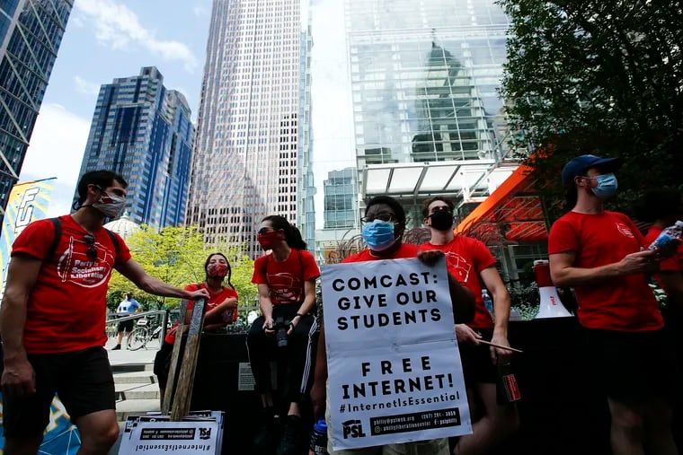 Angel Nalubega holds her sign before protesting at the Comcast Center in Center City on Monday. Advocates, parents, teachers, community members, and students attempted to deliver letters to Comcast CEO Brian Roberts, demanding he open up residential hot spots for students to get online and improve speeds of the Internet Essentials program.