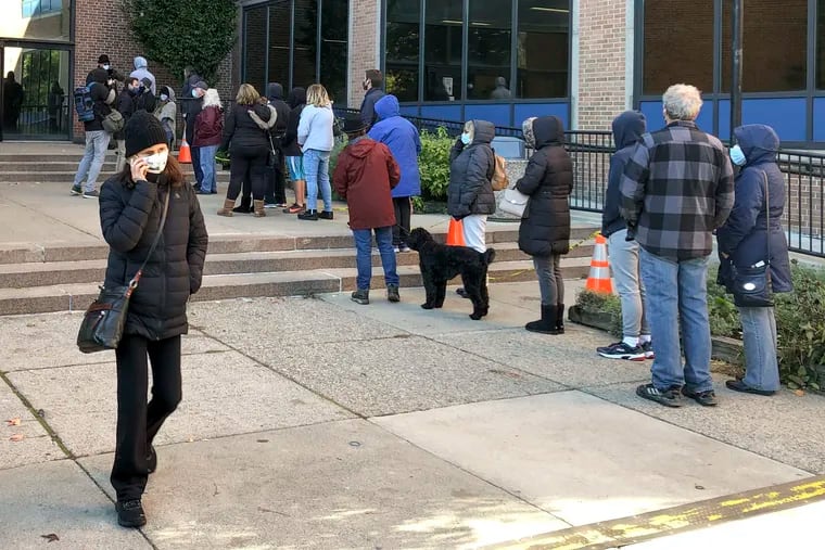 Voters wait in line outside the Bucks County government building Monday in Doylestown. Some said they received word that their mail ballots had problems and needed to be fixed in order to be counted.
