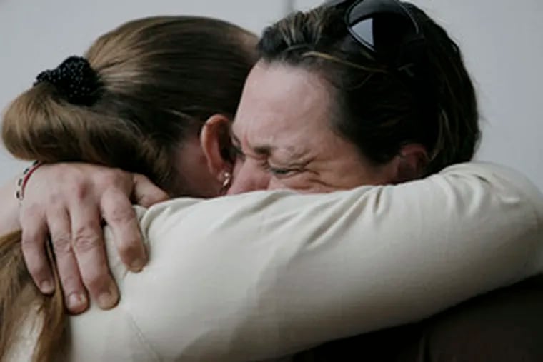 Luann Wilson (right), whose son died in a construction accidentlast year, is comforted by a friend, Rosemary Gomez.