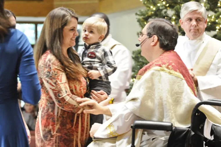 Staff Sgt. Will Trimble's wife, Christi, holding their son Zakk, talks with Marucci at St. Andrew the Apostle Church in Gibbsboro. Marucci married the couple, and baptized Zakk. (Ron Tarver / Staff Photographer)