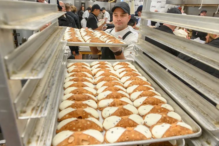 Vincent Termini Jr. loads up a rack of cannoli at Termini Bros. Pastries in South Philadelphia on Dec. 24, 2019.  A broken machine almost derailed Termini's 2021 Christmas celebration. Avi Steinhardt / For the Inquirer
