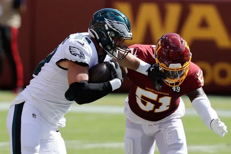 Eagles tight end Dallas Goedert shoves away Washington Football Team linebacker Shaun Dion Hamilton in Sunday's season-opening loss. Goedert caught eight passes for 101 yards and a touchdown, and his continued growth could make it difficult for the Eagles to justify re-signing fellow tight end Zach Ertz.