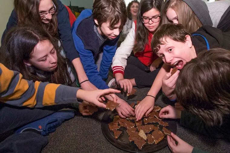 A youth group at Mishkan Shalom synagogue enjoys the chocolate-covered matzo they made.
