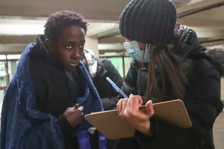 Aisha Childs, 48, right, collects information from Kiki, a woman experiencing homelessness in a corridor near the train station at 15th and Locust Streets. Childs was volunteering to help conduct the Point in Time Youth Count, a census of people living on the street.
