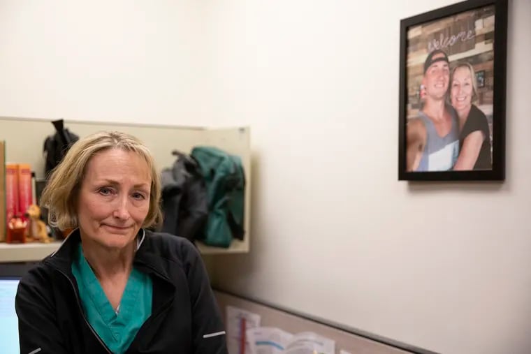 Dr. Bonnie Milas poses for a portrait in her office at the Hospital of the University of Pennsylvania on Thursday, April 18, 2019. Milas, an anesthesiologist at Penn, lost her son, pictured next to her, to an overdose and has since become an advocate for overdose prevention.