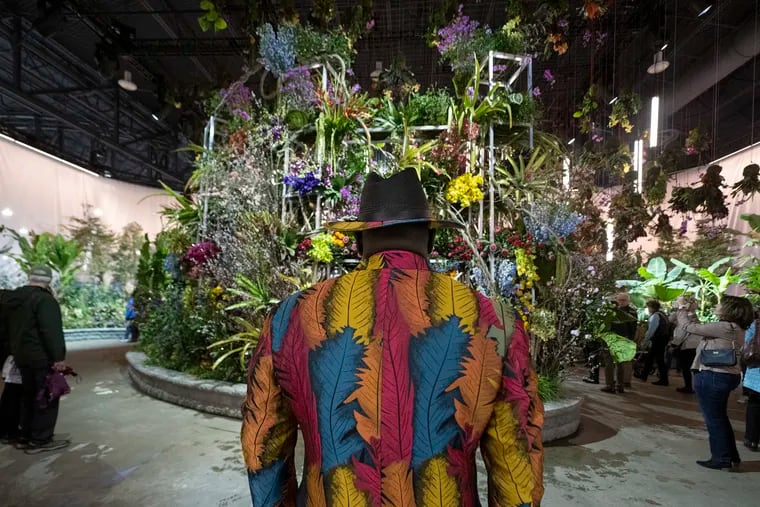 Ramil Carr walks into the entrance of the Philadelphia Flower Show at the Pennsylvania Convention Center Friday.