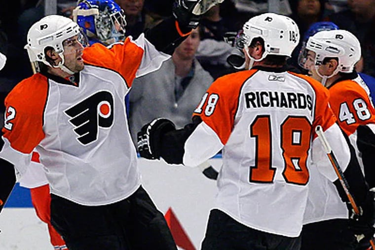 Simon Gagne, center, celebrates with Danny Briere (48) and Mike Richards (18) after scoring one of his three goals. (AP Photo/Julie Jacobson)