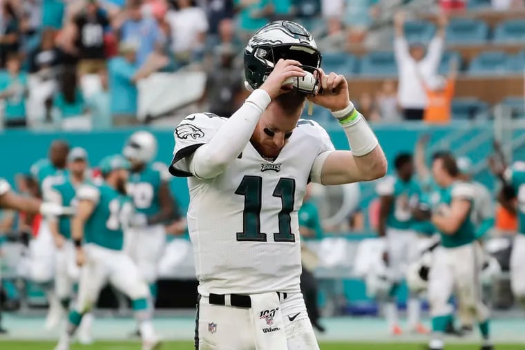 Eagles quarterback Carson Wentz takes off his helmet after losing to the Dolphins, 37-31, the fifth time this season he's failed to bring his team back from a deficit.