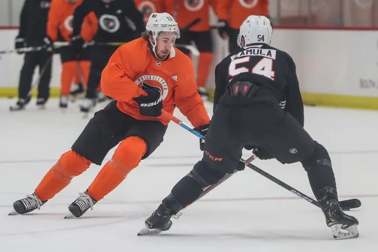 Flyers center Kevin Hayes, left, brings the puck up ice while rookie Egor Zamula defends during training camp Sunday in Voorhees.