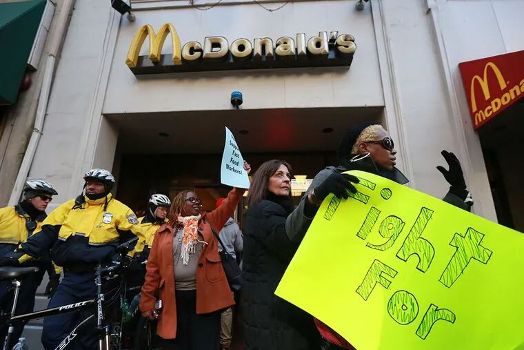 Protesters demonstrate for a higher minimum wage outside McDonald's on Walnut Street on Thursday, December 4, 2014. ( DAVID SWANSON / Staff Photographer )