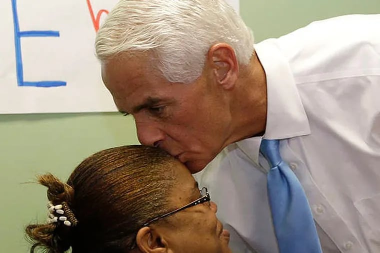 Former Florida Gov. Charlie Crist, right, kisses volunteer Edouine Belot, of Fort Lauderdale, left, on the head during a visit to a phone bank, Monday, Aug. 25, 2014, in Fort Lauderdale,  Fla. Crist is running against Nan Rich for the democratic nomination for Florida Governor. Florida's primary election is Tuesday. (AP Photo/Lynne Sladky)