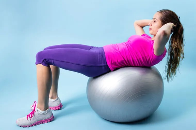 Woman performing crunches on a medicine ball.
