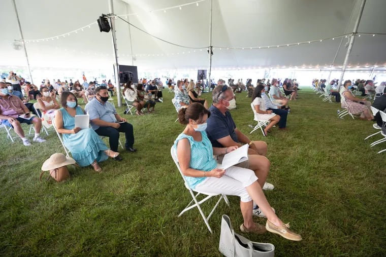 Karen and John Chudzinski, front center, attend a graduation ceremony at Rowan University, Glassboro campus, in New Jersey, July 14, 2020. The university is planning to move away from its mandatory mask mandate indoors. As of Monday, indoor masking will be optional on all campuses under most circumstances.