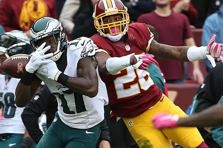 Nelson Agholor (left) can't hold onto a pass as the Redskins' Bashaud Breeland defends.
