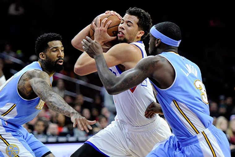 Michael Carter-Williams drives between Denver's Ty Lawson (right) and Wilson Chandler. (Tom Gralish/Staff Photographer)