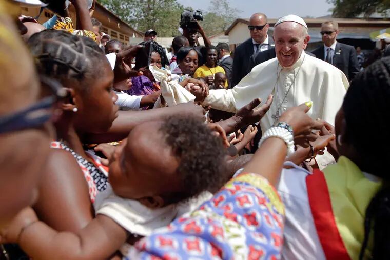 Pope Francis is cheered by locals as he visits a refugee camp in Bangui, Central African Republic. The pope arrived Sunday in the capital of Central African Republic, his final stop in Africa.