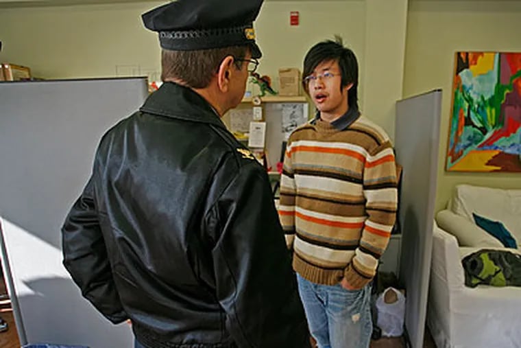 Wei Chen, 18, president of the Chinese American Student Association at South Philadelphia High School, speaks with James Tiano, Chief Inspector for the Community Affairs Bureau of the Philadelphia Police Department, on Monday. (Alejandro A. Alvarez / Staff Photographer)