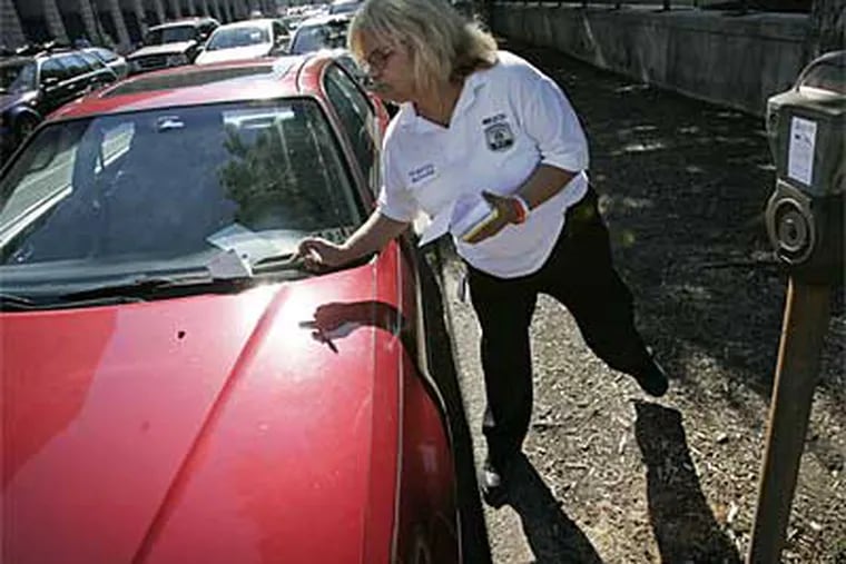 Hilda Bielecki of the Philadelphia Parking Authority tickets a car last year. The television series 'Parking Wars' is beginning to pay dividends for the city. (File photo)