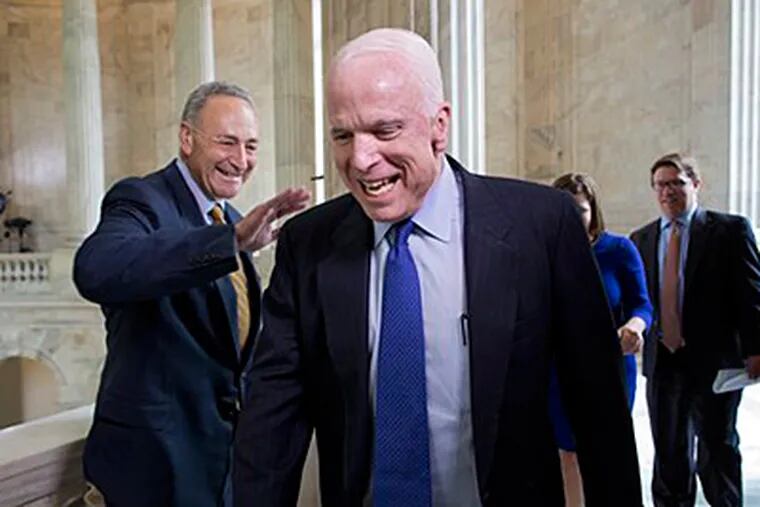 Sen. John McCain, R-Ariz., laughs as he and Sen. Chuck Schumer, D-N.Y., left, cross paths at competing TV news interviews just before a vote in the Senate on legislation to collect sales tax on internet purchases, on Capitol Hill in Washington, Monday, May 6, 2013.  (AP Photo/J. Scott Applewhite)