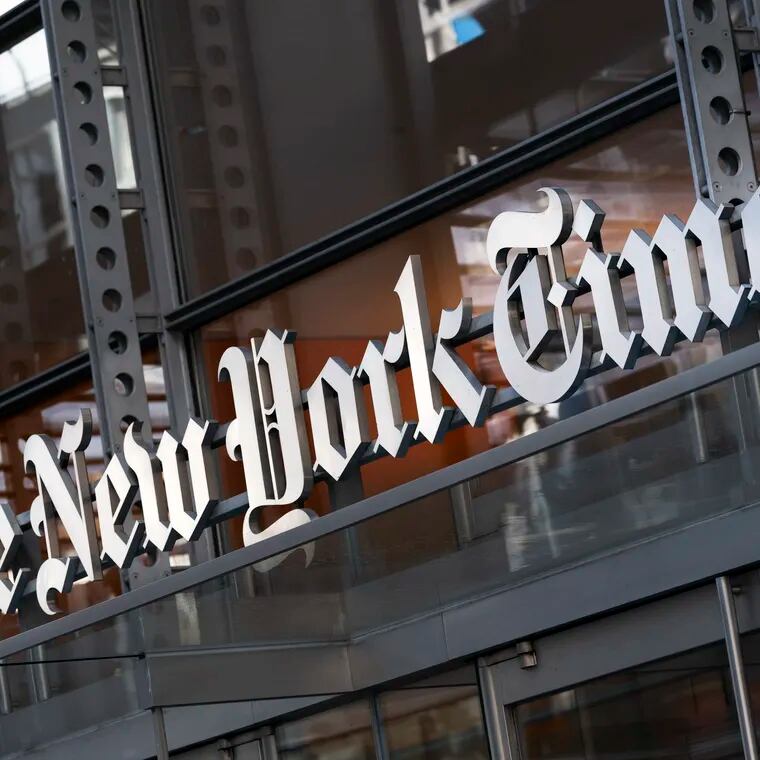 A sign for The New York Times hangs above the entrance to its building, May 6, 2021, in New York.