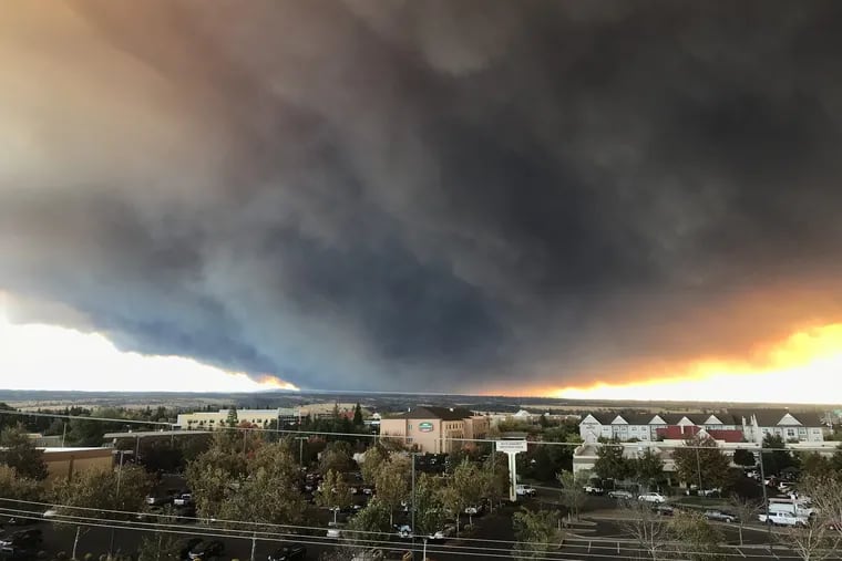 The massive plume from the Camp fire, burning in Feather River Canyon near Paradise, Calif., wafts over the Sacramento Valley as seen from Chico, Calif.